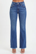 A person wearing medium-wash blue denim jeans with a frayed hem, shown from the waist down against a plain light background.