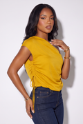 Mustard yellow asymmetrical silk blouse with drawstring detail, worn with dark denim, showcasing a relaxed fit and elegant style.