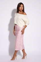 Dusty pink zebra print satin midi skirt with a bias cut, paired with a light off-shoulder sweater and clear heels.