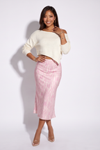Dusty pink zebra print satin midi skirt with a bias cut silhouette, styled with a cropped cream sweater and transparent heels.