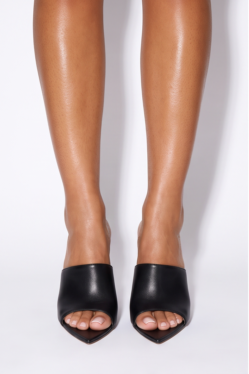 Black pointed toe stiletto high heel mules with a slip-on design, showcasing an open toe and single-band upper.